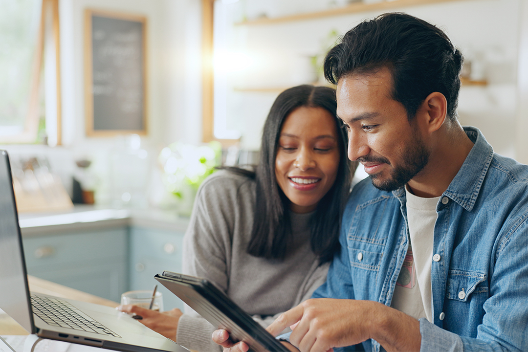 woman and man smiling looking at eTablet