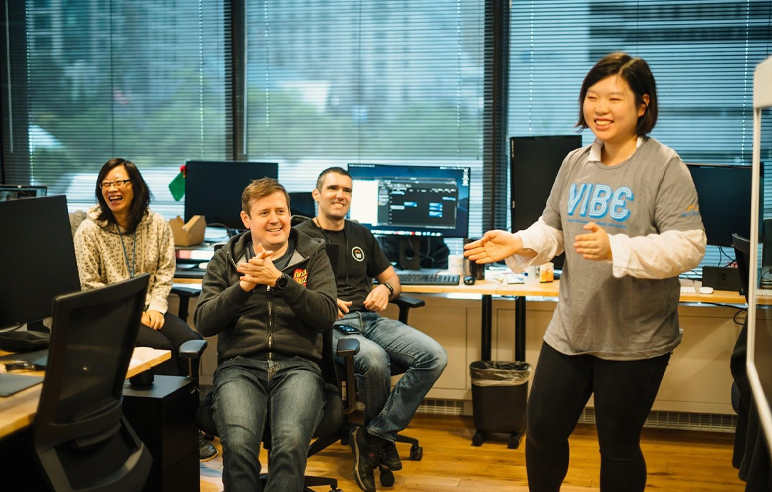 workday employees sitting at desks smiling