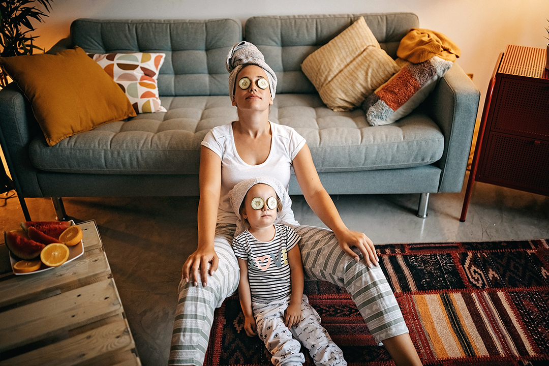 woman and child having facials with hair wrapped in towels and cucumbers on their eyes